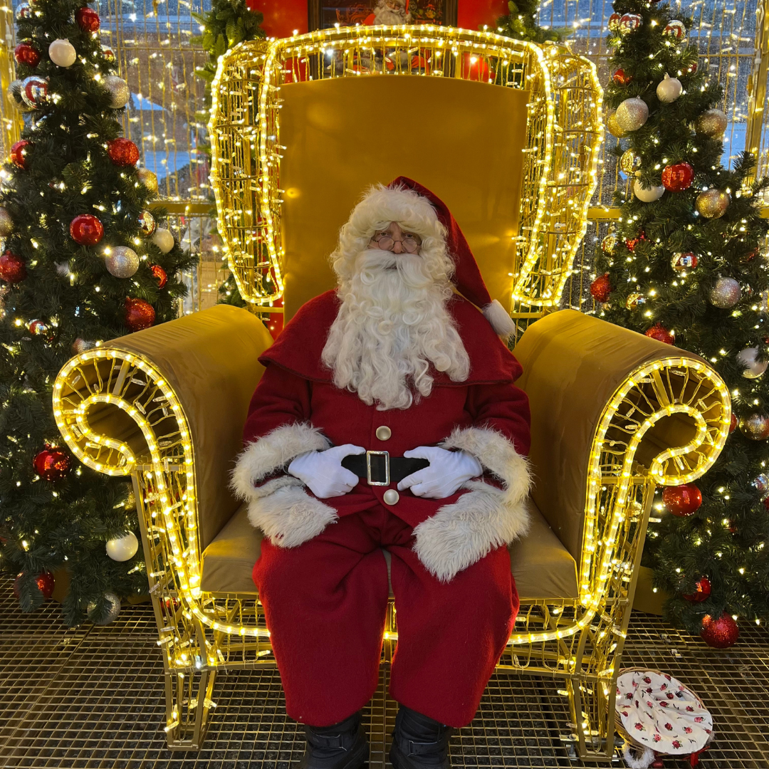 père Noël père Noël assis dans sa maison illuminée