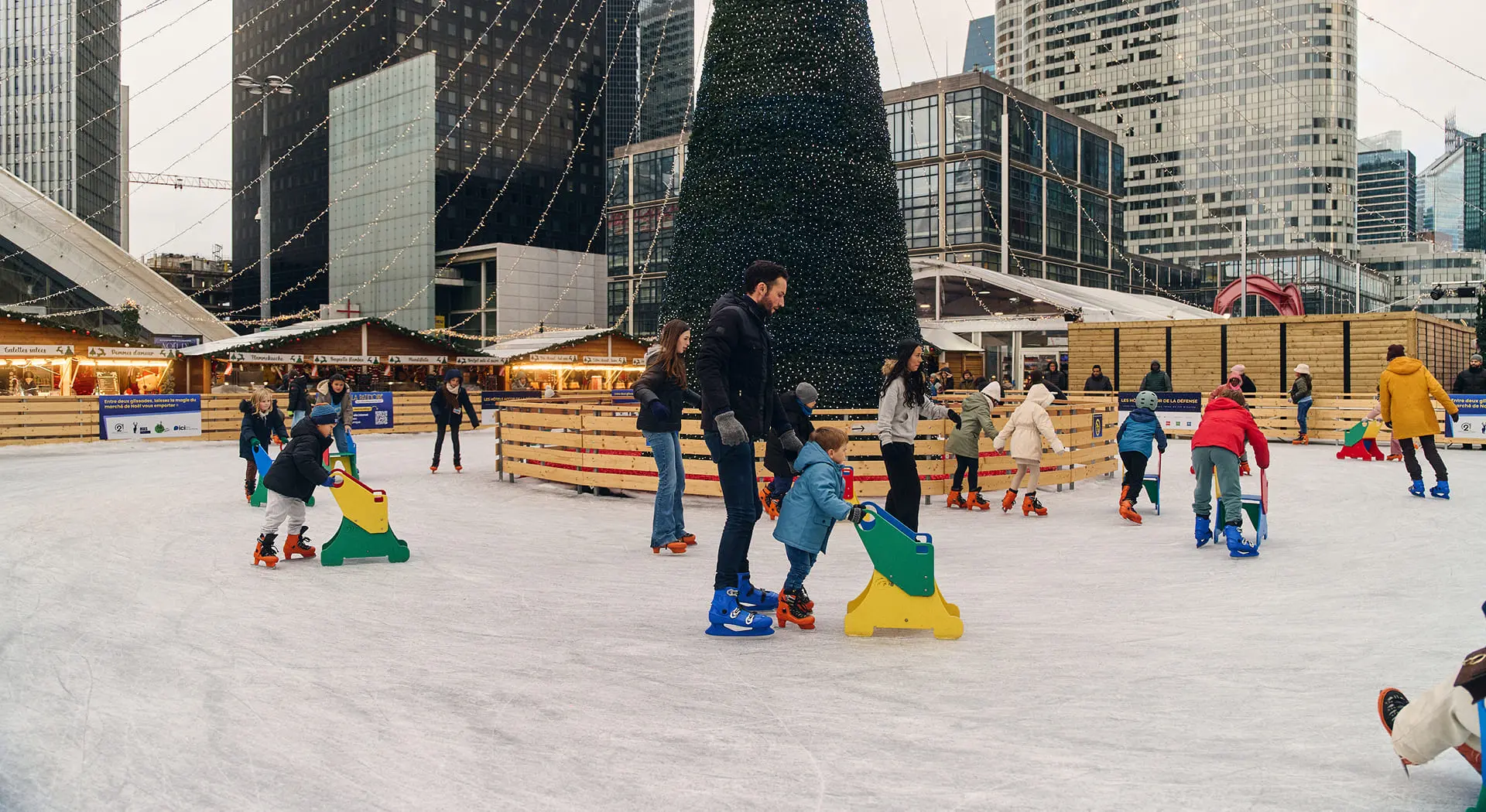 Famille sur la patinoire du marché de Noël Paris La Défense